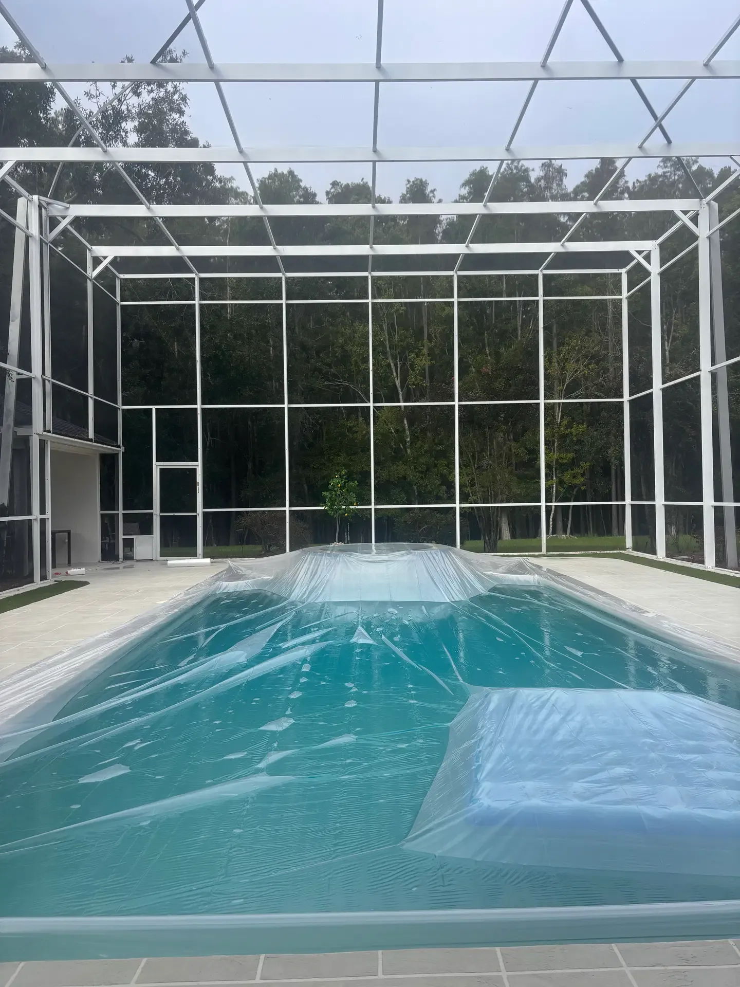 Pool covered as part of screen repair preparation at a Cheval enclosure.